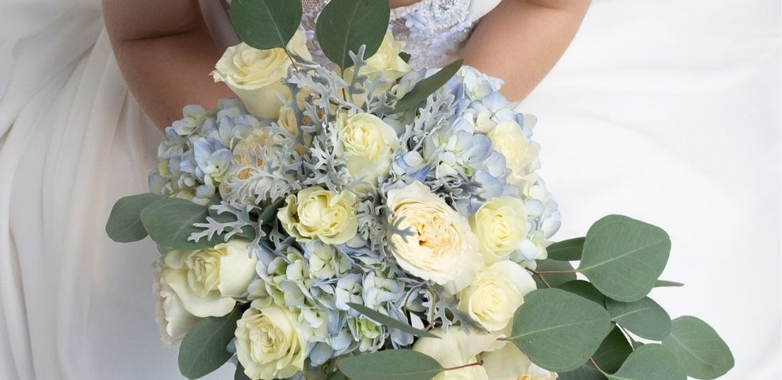 Bride holding a flower bouquet with hydrangeas in it.