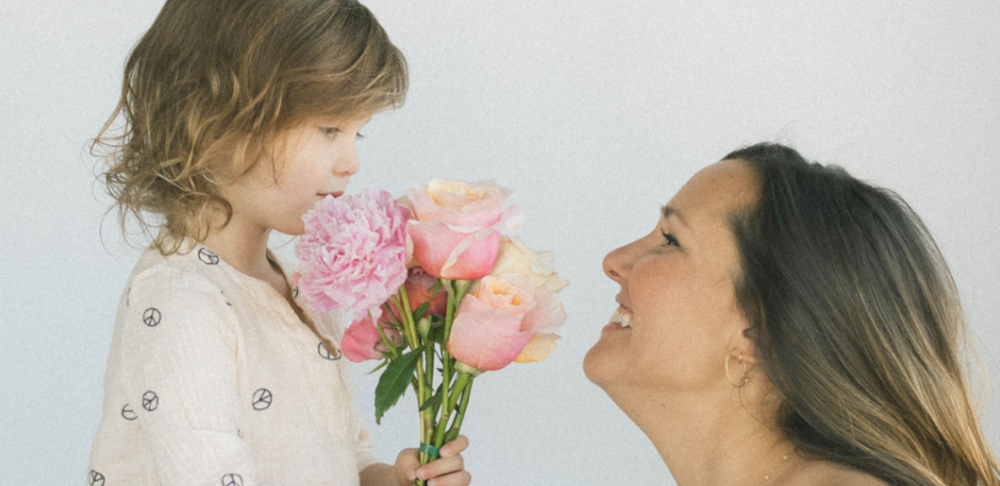 Mother and daughter enjoying the beauty of fresh flowers for Mother's Day